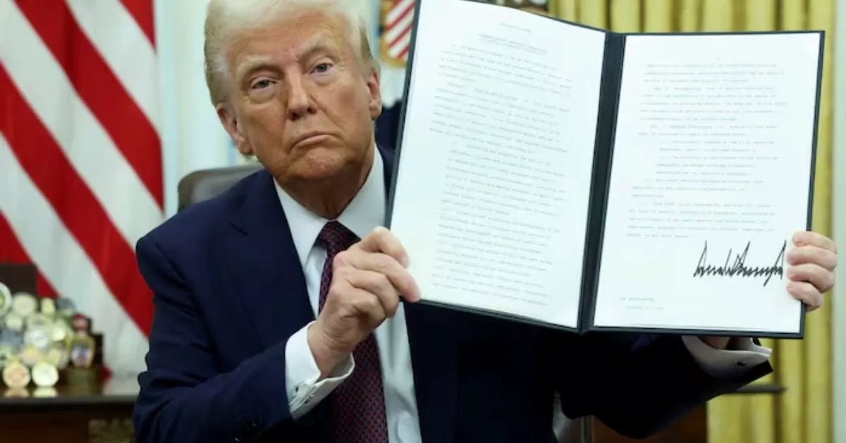 On January 23, 2025, U.S. President Donald Trump is seen holding a signed executive order related to cryptocurrencies in the Oval Office at the White House, Washington, D.C.